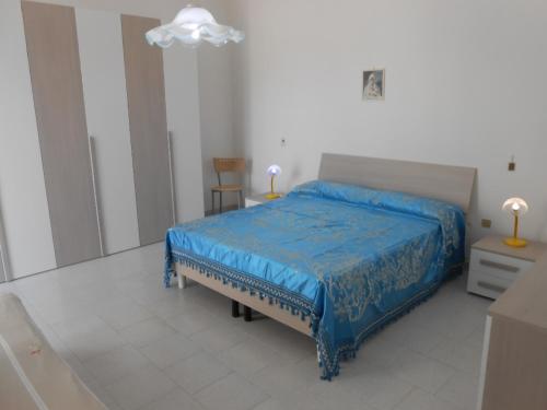 una camera con letto e piumone blu di Casa Raffaele a Leuca