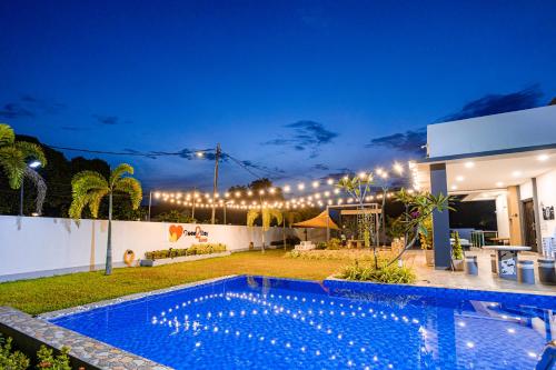 a swimming pool in front of a house at night at Good2Stay Villa in Melaka