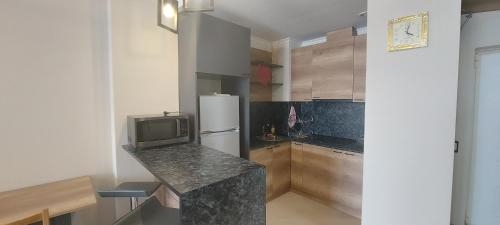 a kitchen with a refrigerator and a tv on a counter at Good Rest apartment in Tsaghkadzor