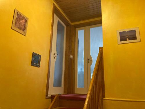 Cette chambre jaune est dotée d'un escalier avec un mur jaune. dans l'établissement Světlá nad Sázavou dům s výhledem, à Světlá nad Sázavou