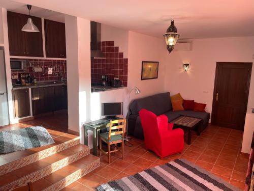 sala de estar con sofá y silla roja en Casandalusí en Frigiliana