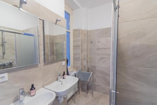 uma casa de banho com 2 lavatórios e um chuveiro em hostel mapijaru em Klagenfurt