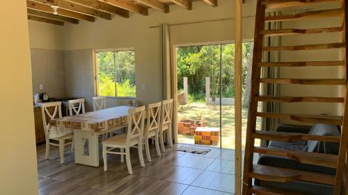 cocina con mesa, sillas y ventana en Toca do Siri, en Imbituba