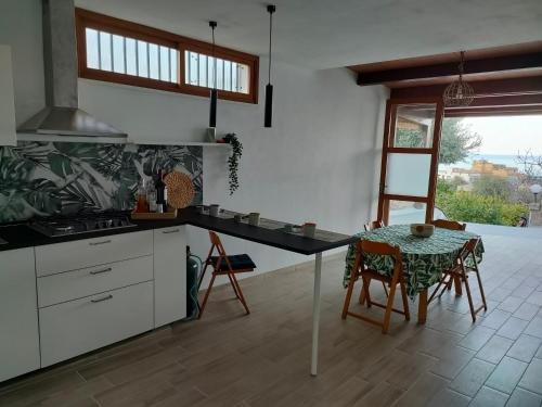 een keuken met een tafel en een tafel en stoelen bij mdresort villa fronte mare in Trabia