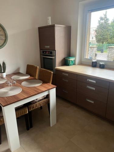 une cuisine avec une table, un comptoir et une fenêtre dans l'établissement Apartament Rumia 45, à Rumia