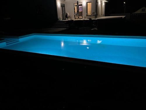 a large blue swimming pool in a dark room at Pensiunea Mandala 