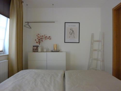 ザンクト・ペーター・オルディングにあるFerienwohnung Nis Randersの白いベッドルーム(ベッド1台、はしご付)