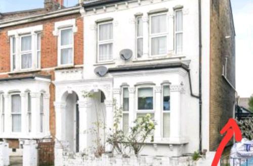 a red arrow pointing to a white house at Room with luxury private bathroom and independent entrance near Tube in London
