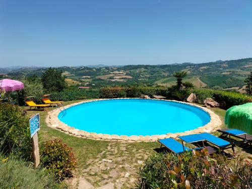 einen Pool mit Stühlen und Sonnenschirmen im Hof in der Unterkunft Old House in Penna San Giovanni