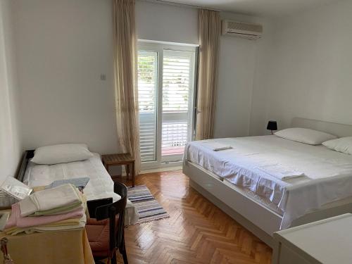 a bedroom with two beds and a window in it at Rooms Jelena in Dubrovnik