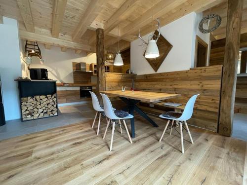 a kitchen with a wooden floor and a wooden table and chairs at Ferienhaus Karlchen in Oberaichwald