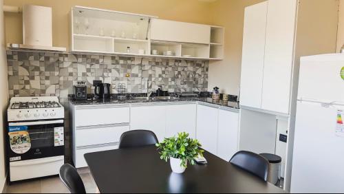 a kitchen with a table and chairs and a refrigerator at Departamentos Rosina 1 in San Fernando del Valle de Catamarca