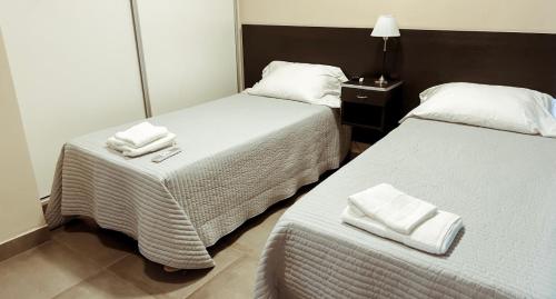 two beds in a hotel room with towels on them at Departamentos Rosina 1 in San Fernando del Valle de Catamarca