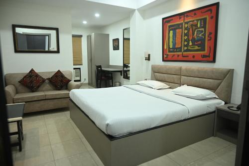 sypialnia z dużym łóżkiem i kanapą w obiekcie ELGIN SUITES w mieście Kolkata