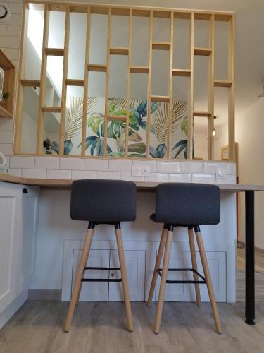 un bar avec deux tabourets devant un miroir dans l'établissement Home Suite Metz & Place de parking privée, à Metz