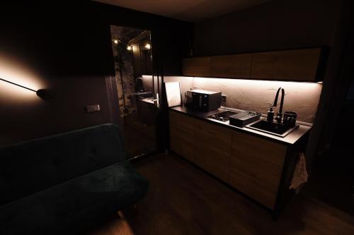 a dark kitchen with a sink and a microwave at KONTAINERLOFT in Laz