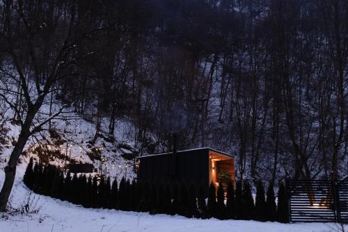 a small cabin in the snow at night at KONTAINERLOFT in Laz
