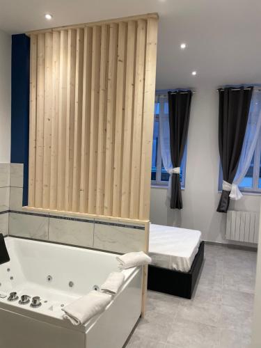- une salle de bains avec baignoire et un lit dans une chambre dans l'établissement Les Bulles de Mona "Le 149" -PROXIMITE GARE DE LYON-, à Lyon
