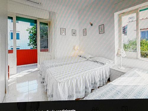 a bedroom with two beds and a window at Elegante e centralissimo appartamento in villa in Ischia