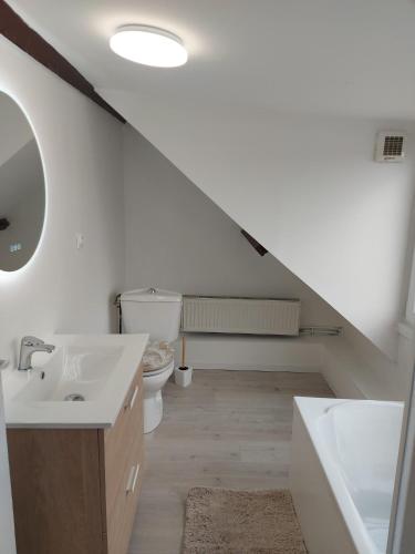 La salle de bains blanche est pourvue d'un lavabo et de toilettes. dans l'établissement Le hygge, à Boulogne-sur-Mer