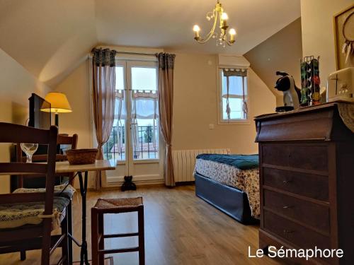 a bedroom with a bed and a table and a dresser at Du coté de chez Swann 1 in Trouville-sur-Mer
