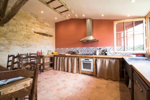 - une cuisine avec des murs rouges et un comptoir dans l'établissement Le chant des pierres - douceur et nature, à Les Marthres