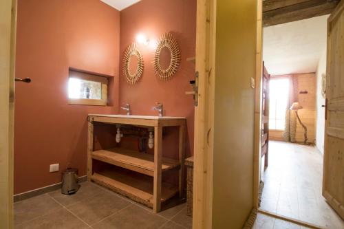La salle de bains est pourvue d'un lavabo et d'un miroir mural. dans l'établissement Le chant des pierres - douceur et nature, 