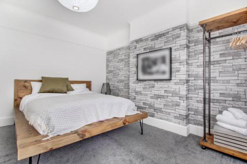 Un dormitorio con una pared de ladrillo y una cama en West Midlands Contractor - LongStay - Parking - 4 Beds - Pet Friendly, en Sleightholme