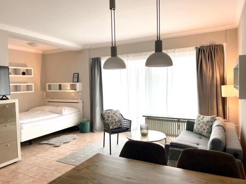 uma sala de estar com uma cama, um sofá e uma mesa em Bellevue 16 KaMare - direkte Strandlage em Scharbeutz
