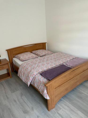 1 dormitorio con 1 cama con marco de madera en Au cœur des Vosges, en Saint-Étienne-lès-Remiremont