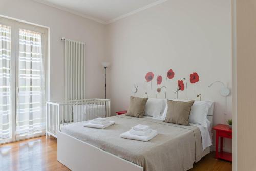 a white bedroom with a bed with two towels on it at Casa Torre di Specchio 2 con Piscina in Bari