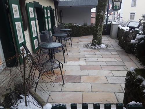 a patio with chairs and tables in the snow at Hotel Feiler in Muggendorf