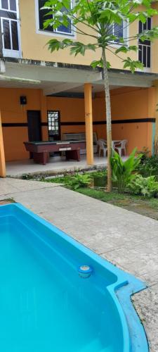 uma piscina azul em frente a uma casa em Hospedagem Recanto do Lago em Angra dos Reis