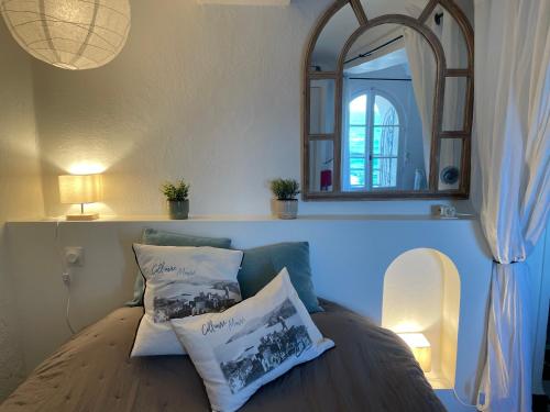 una camera da letto con specchio e divano con cuscini di Château de la Rocasse a Collioure