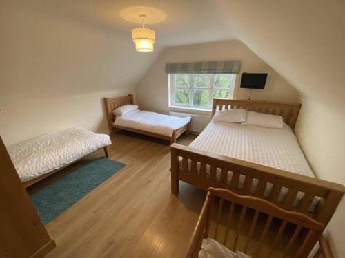 een slaapkamer met 2 bedden en een raam bij Erne Retreat in Tully