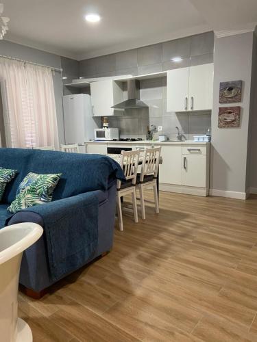 a living room with a blue couch and a kitchen at Apartamento Venus in Salar