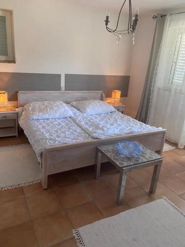 a bedroom with a bed and a table in it at Casa Fumica Apartment in Palit