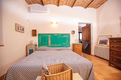 Schlafzimmer mit einem großen Bett mit einem grünen Kopfteil in der Unterkunft Affitti Brevi Toscana - Ospitalità in Campagna in Talamone