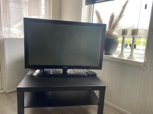 a monitor on a black table in a room with a window at Appelscha aan de diek in Appelscha
