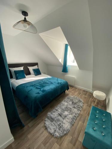 1 dormitorio con cama con sábanas azules y alfombra en L'Etape Zen, en Tulle