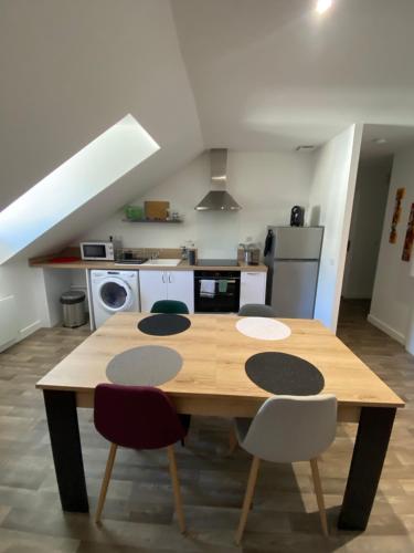 a kitchen with a wooden table and some chairs at L'Etape Zen in Tulle
