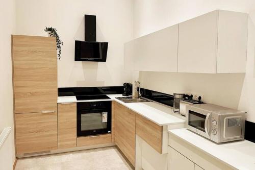 una cucina con armadietti bianchi e forno a microonde di City-Center-Apartment Hip Area, Big & New a Vienna