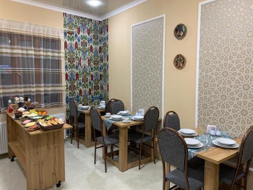 a dining room with tables and chairs and a window at OLD SAFARI HOTEL make yourself at home in Bukhara