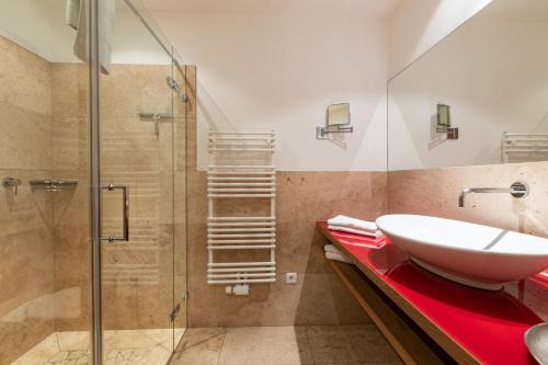 a bathroom with a sink and a glass shower at Ferienlandhaus Alpinum in Lenggries