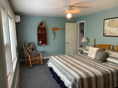 a bedroom with a bed and a chair and a window at Chateau Country Inn and Captain's Cottage in Clayton