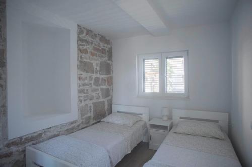 特里班的住宿－Apartman Ferara，一间卧室设有两张床和砖墙