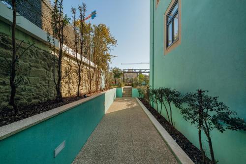 a walkway next to a green building with trees at Oporto Pool Apartment by Vacationy in Porto