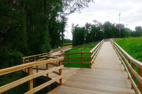 a wooden bridge with a wooden fence on it at Apartamento Ría de Arousa in Boiro