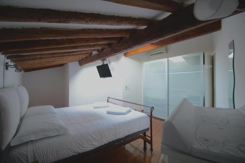 ein Schlafzimmer mit einem weißen Bett und einem Fenster in der Unterkunft Kia Orana Guesthouse in Livorno