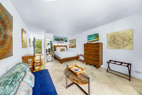 a living room with a blue couch and a bed at DOWNTOWN PARADISE GARDEN HOTEL CONDO with Hot Tub, Pool & Beach in Kailua-Kona